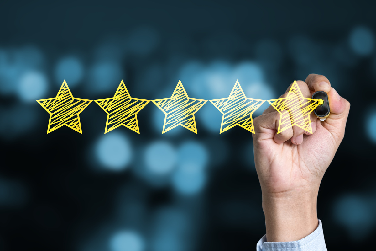 Businessman writing yellow five star to customer evaluation service and product. Marketing review and evaluation concept.